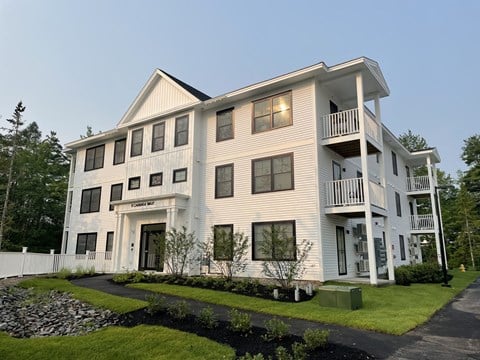 A large white building with a balcony on the second floor.
