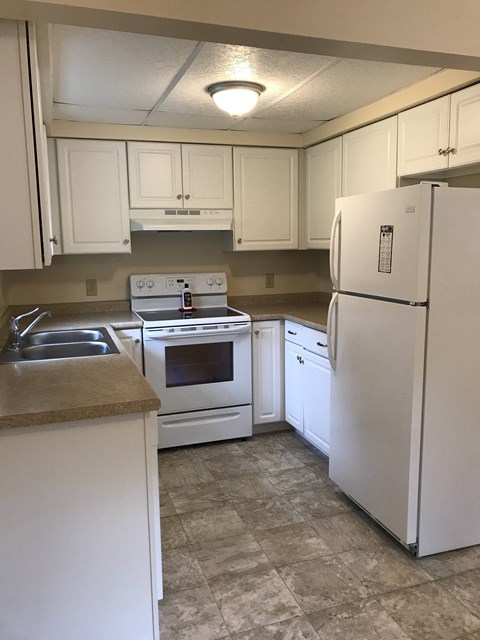 a kitchen with white appliances and white cabinets