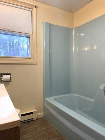 a bathroom with a tub and a sink and a window