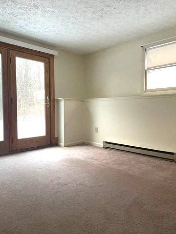 an empty living room with a door and a window
