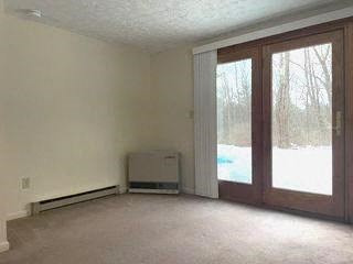 an empty living room with sliding glass doors and a heater