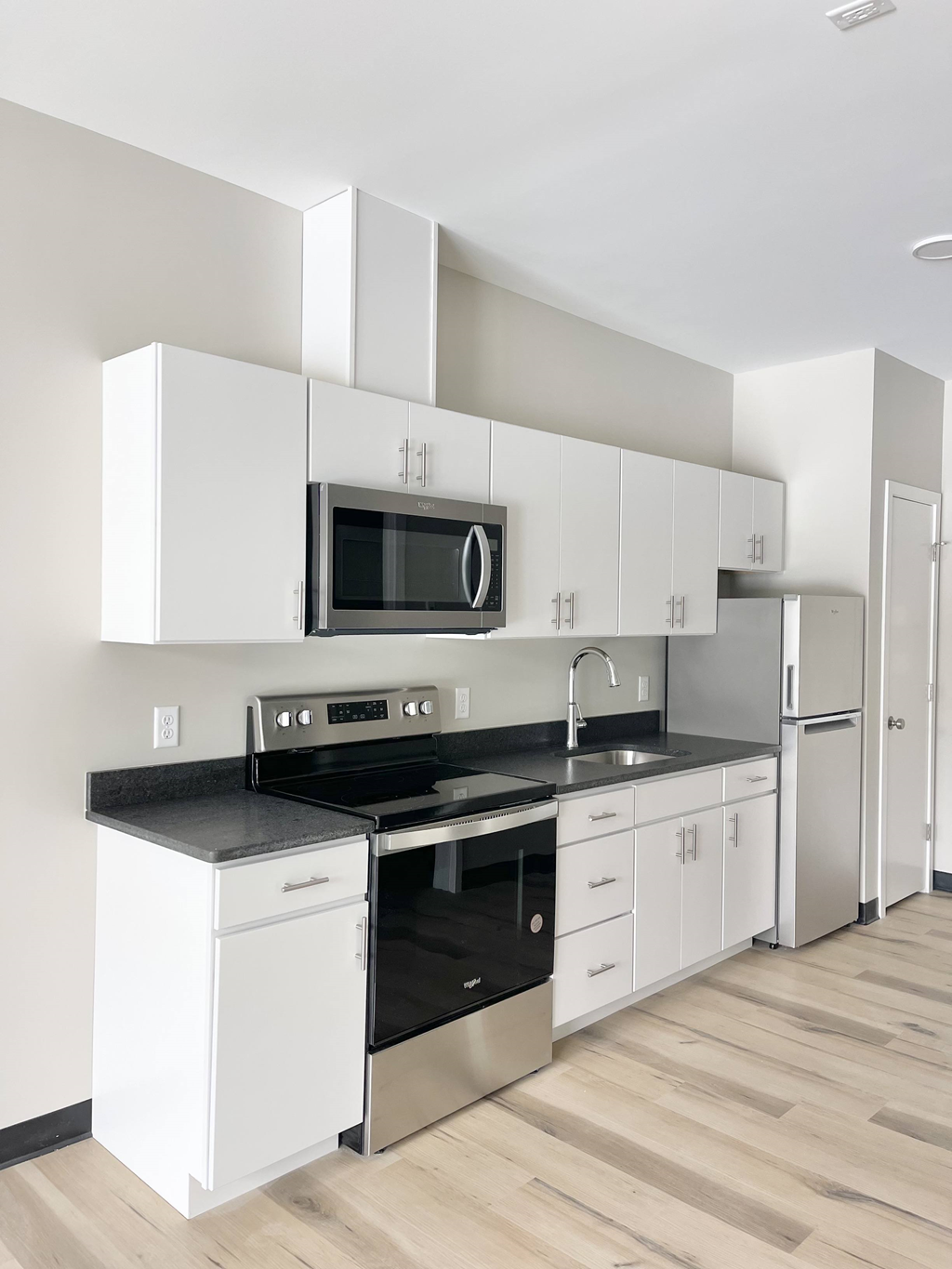 a kitchen with white cabinets and a stove and a microwave