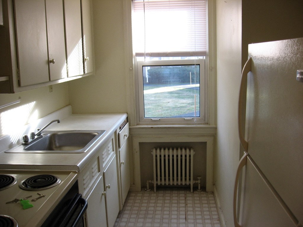 an empty kitchen with a sink and a window
