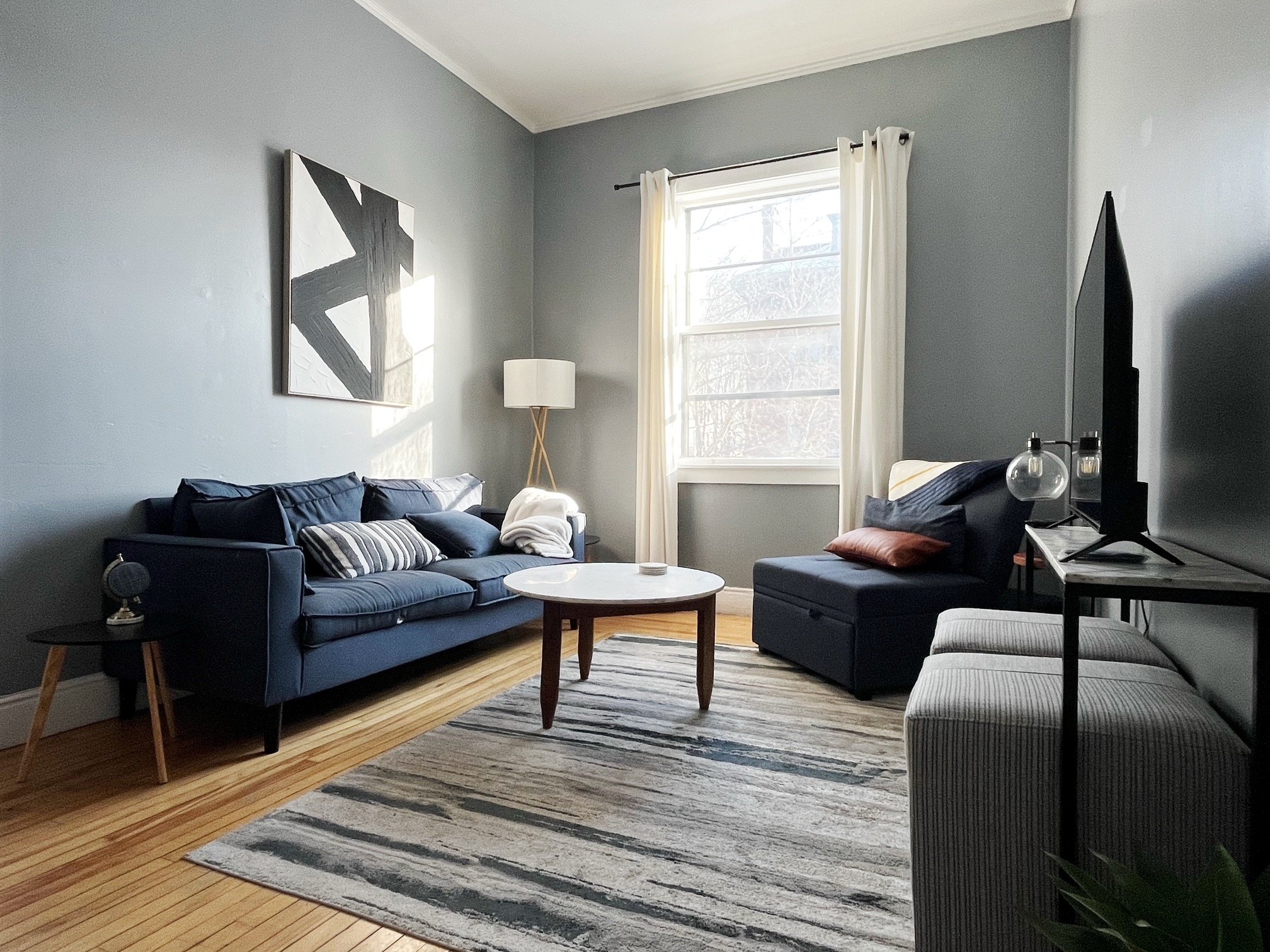 A living room with a blue couch, a coffee table, and a lamp.