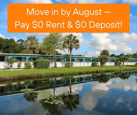 A serene lakeside view with a building in the background and a sign that reads "Move in by August – Pay $0 Rent & $0 Deposit!".