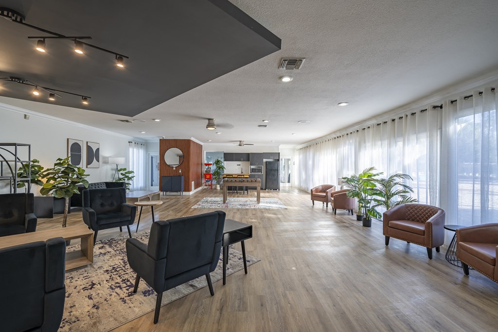A living room with black chairs and a wooden floor. at Red Bay Apartment Complex, Jacksonville, FL, 32211