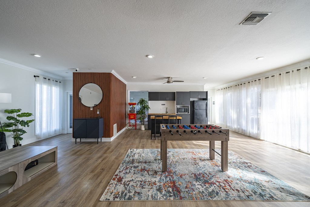 A living room with a wooden floor and a large rug. at Red Bay Apartment Complex, Jacksonville, FL, 32211