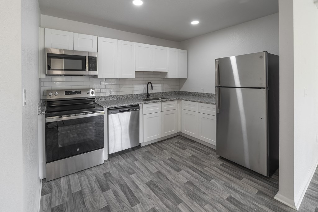 A kitchen with a refrigerator, oven, and microwave. at Red Bay Apartment Complex, Jacksonville, FL, 32211
