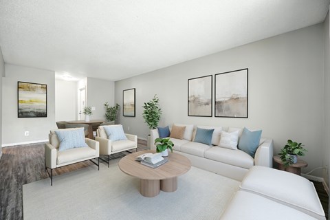 A living room with a white couch, a coffee table, and a painting on the wall.