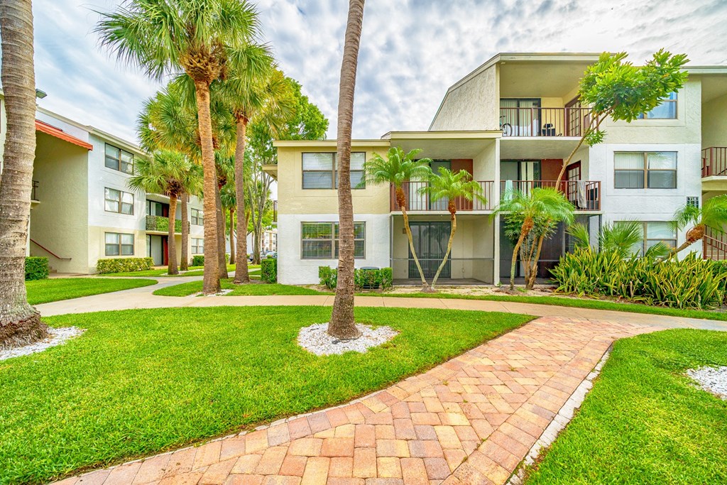 a building with palm trees and a pathway in front of it