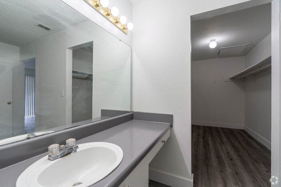 a bathroom with a sink and a mirror at Red Bay Apartment Complex, Jacksonville, Florida