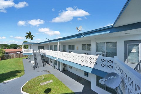 an exterior view of a motel with a blue sky in the background