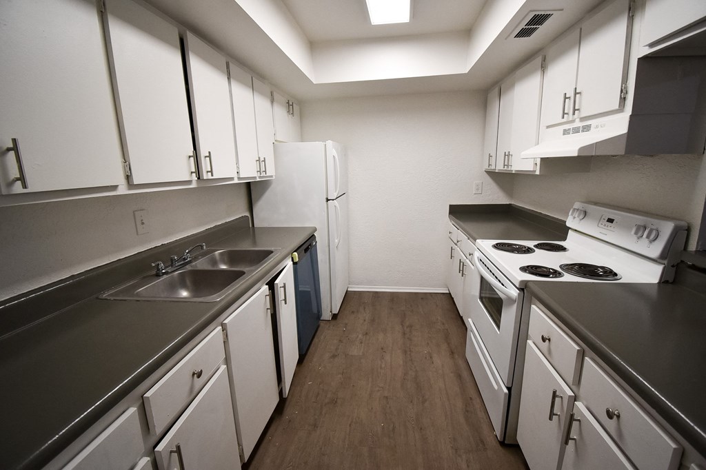 an empty kitchen with white cabinets and appliances and a sink at Red Bay Apartment Complex, Jacksonville, FL, 32211