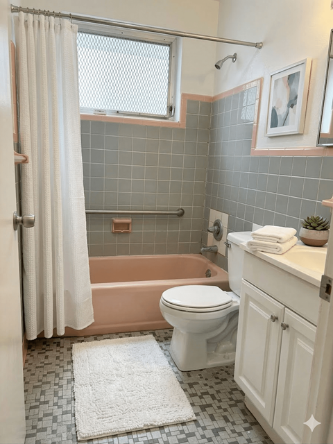 A bathroom with a toilet, tub, and sink.