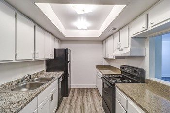 a kitchen with white cabinets and black appliances - Photo Gallery 48