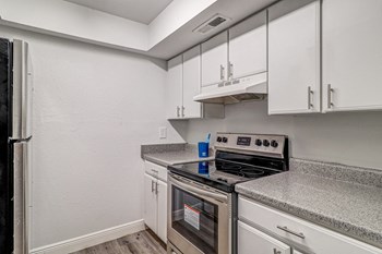 a kitchen with white cabinets and stainless steel appliances - Photo Gallery 46