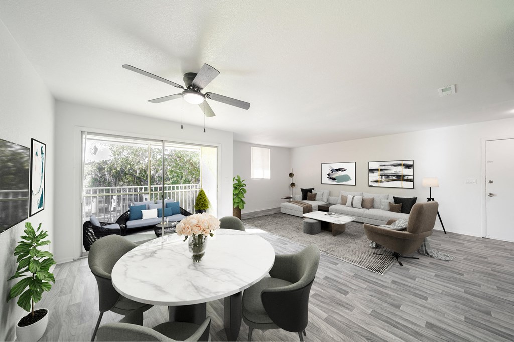 A living room with a white ceiling fan and grey chairs. at Red Bay Apartment Complex, Jacksonville, FL, 32211