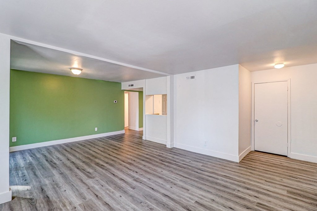 a living room with green and white walls and a wooden floor