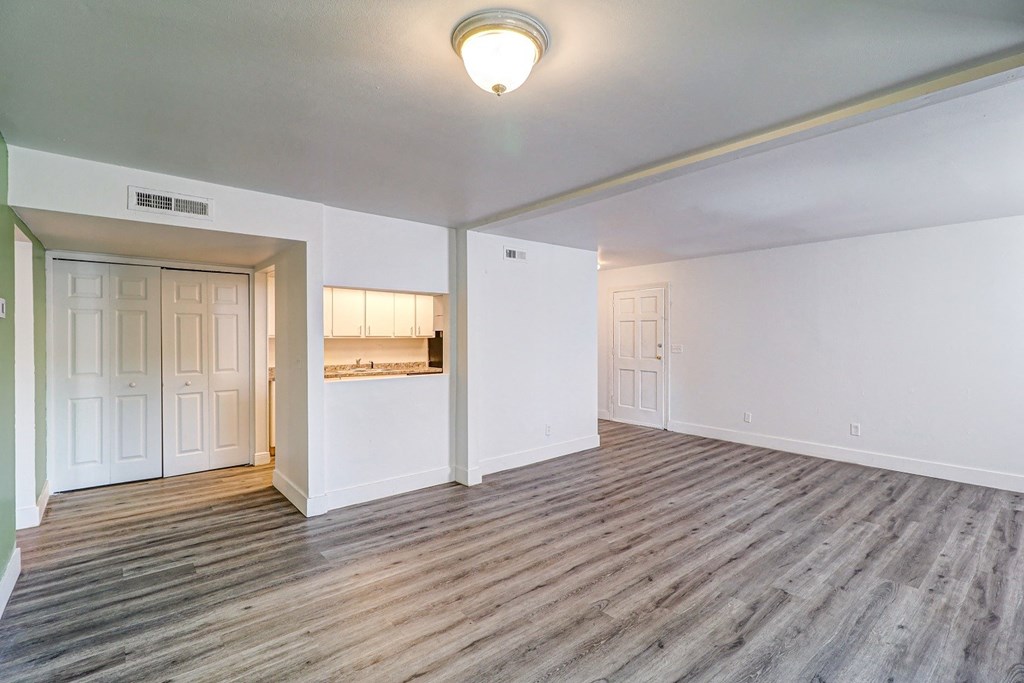 a living room with hardwood floors and white walls