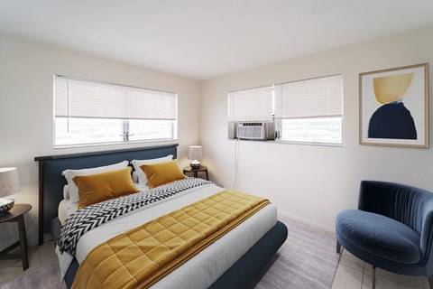 a bedroom with a bed and two windows