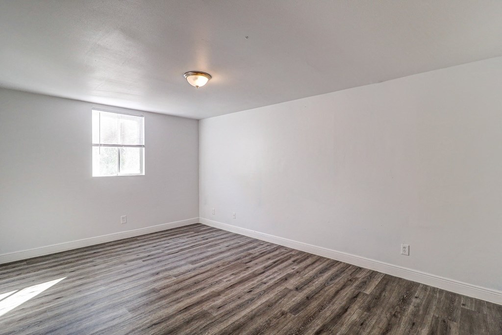 a bedroom with white walls and a window