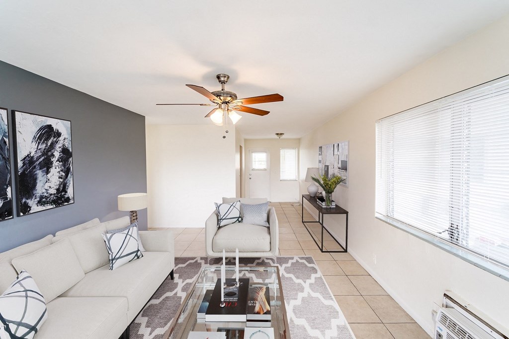a living room with white couches and a glass coffee table