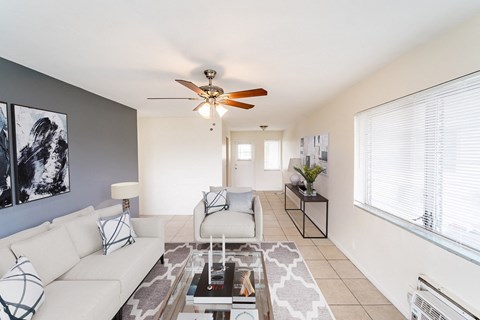 a living room with white couches and a glass coffee table