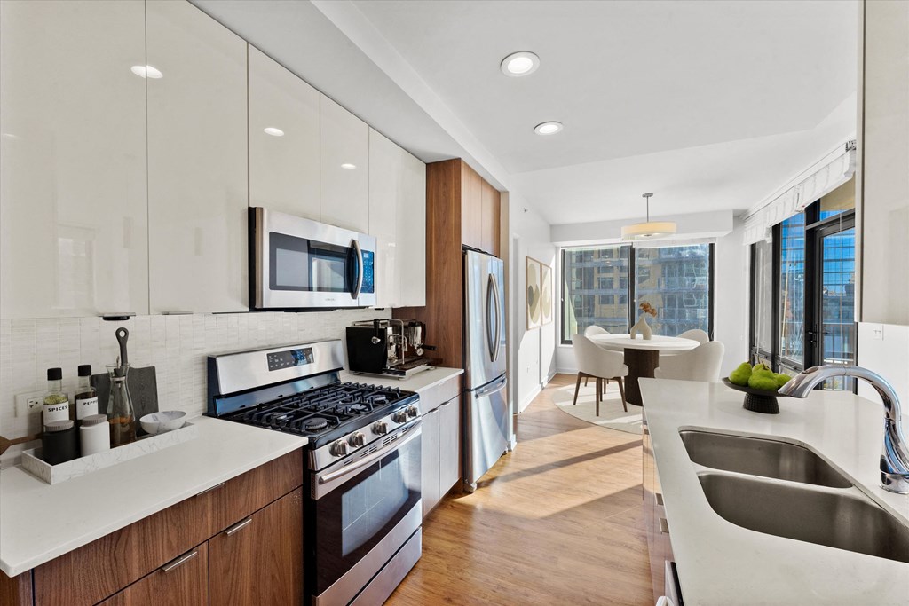 A modern kitchen with a stove, sink, and refrigerator at Chateau on Wells, Illinois, 60654