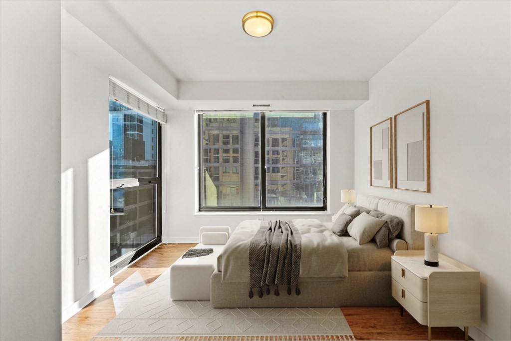 A bedroom with a large bed and a window overlooking a cityscape at Chateau on Wells, Illinois