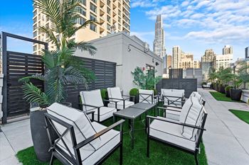 A patio with white furniture and a palm tree at Chateau on Wells, Chicago, 60654