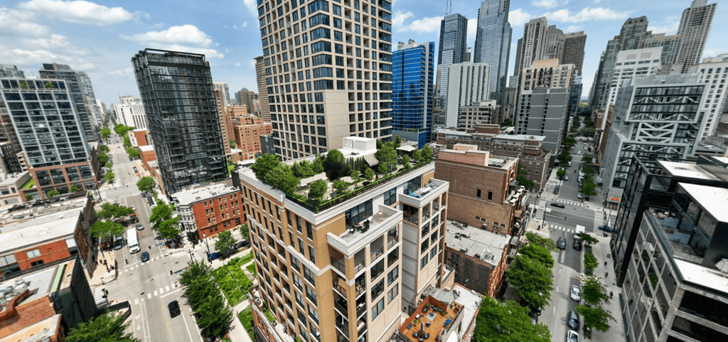 an aerial view of a city with trees on top of buildings at Chateau on Wells, Chicago, Illinois