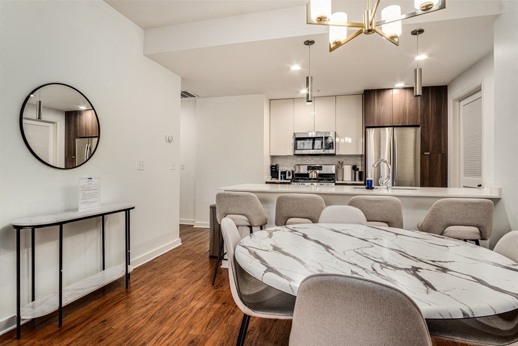 A modern kitchen with a marble table and chairs.