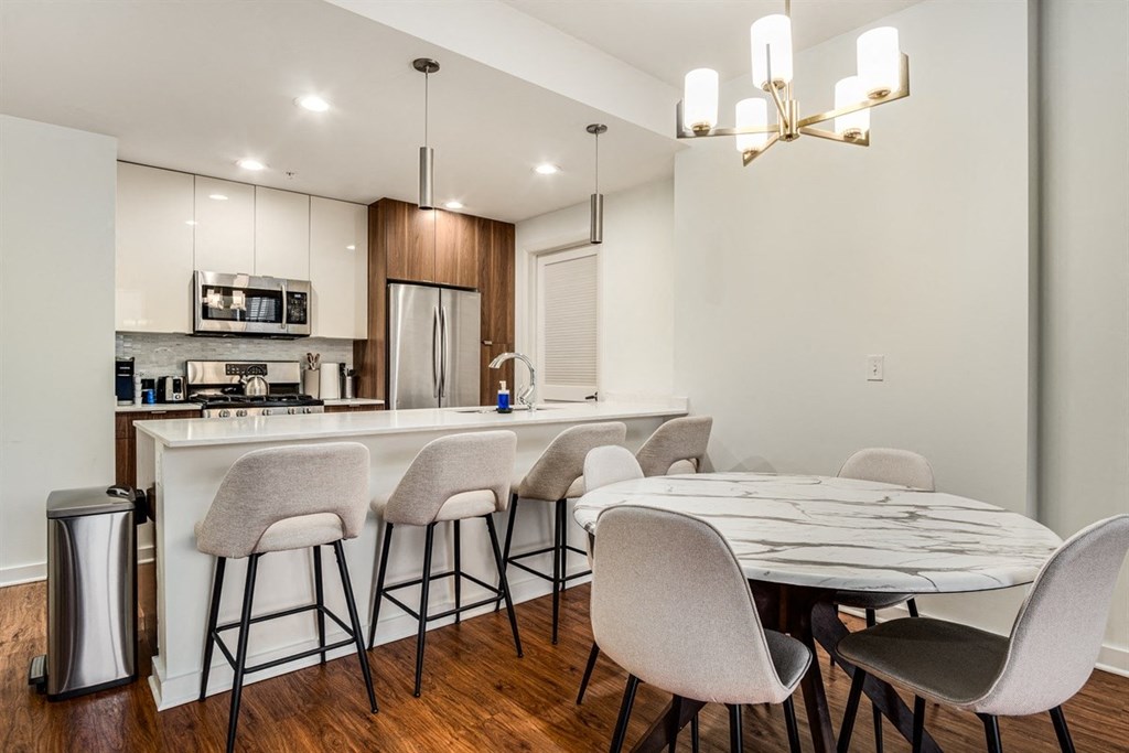 A modern kitchen with a bar area and a dining table set up.
