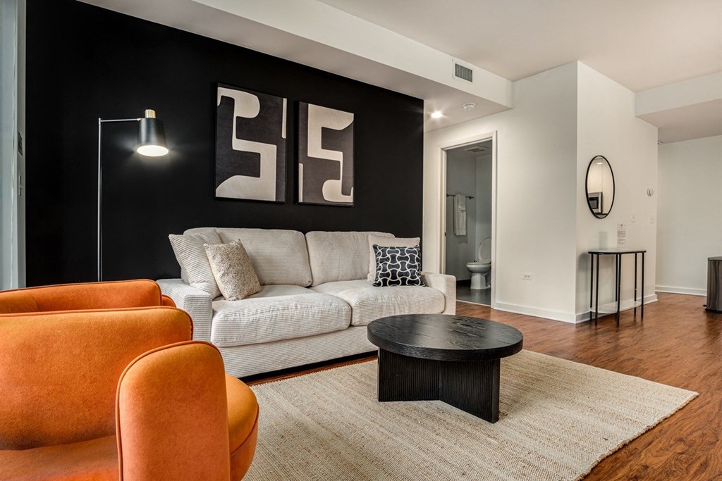 A living room with a white couch, a black coffee table, and a floor lamp.
