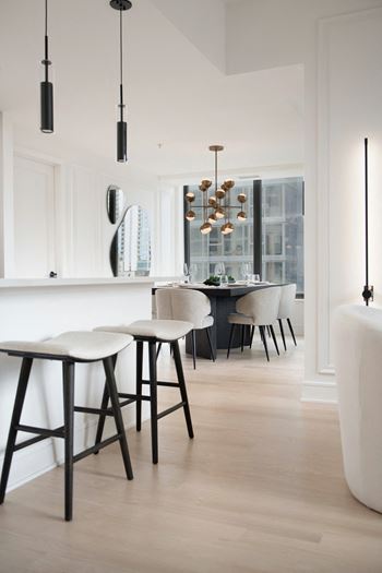 a dining room with a table and chairs and a kitchen at Chateau on Wells, Chicago, IL