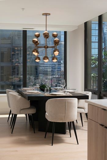 a dining room with a table and chairs and a large window at Chateau on Wells, Chicago, 60654