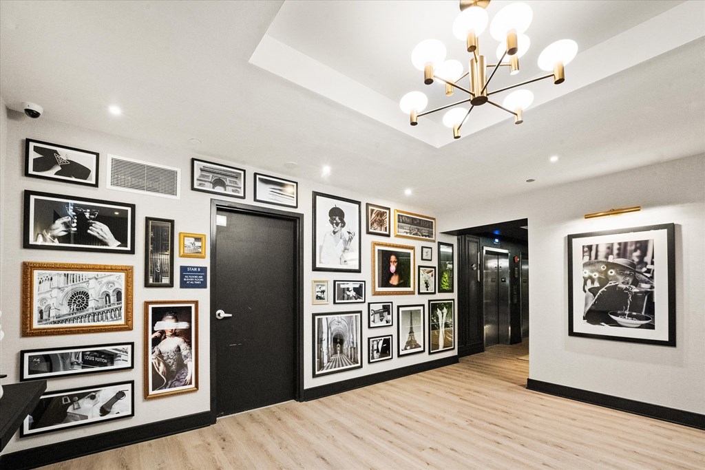 A hallway with a chandelier and pictures on the wall at Chateau on Wells, Chicago, 60654