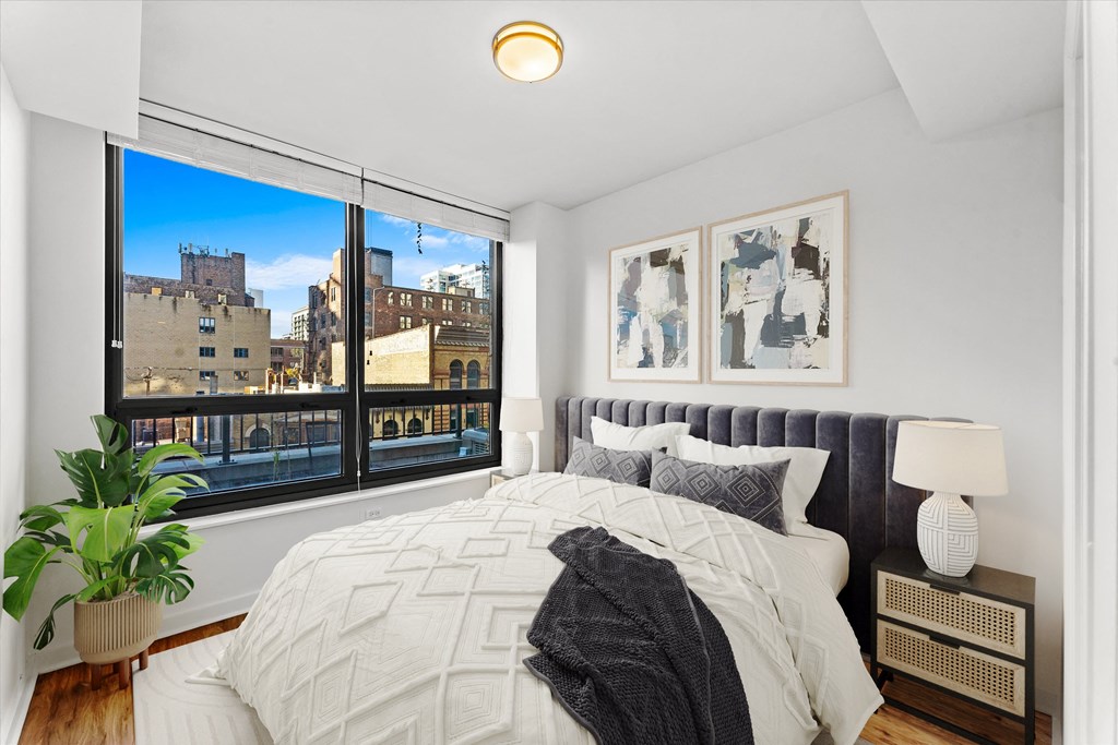 A bedroom with a large bed and a view of the city at Chateau on Wells, Chicago, IL
