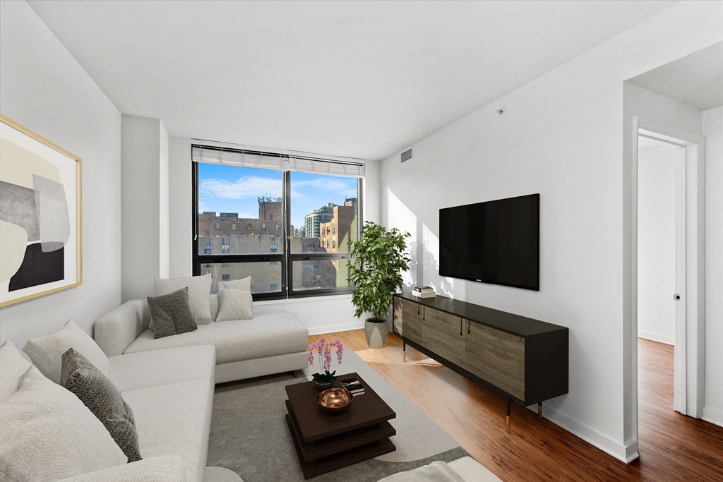 A modern living room with a large window and a flat screen TV. at Chateau on Wells, Chicago, Illinois