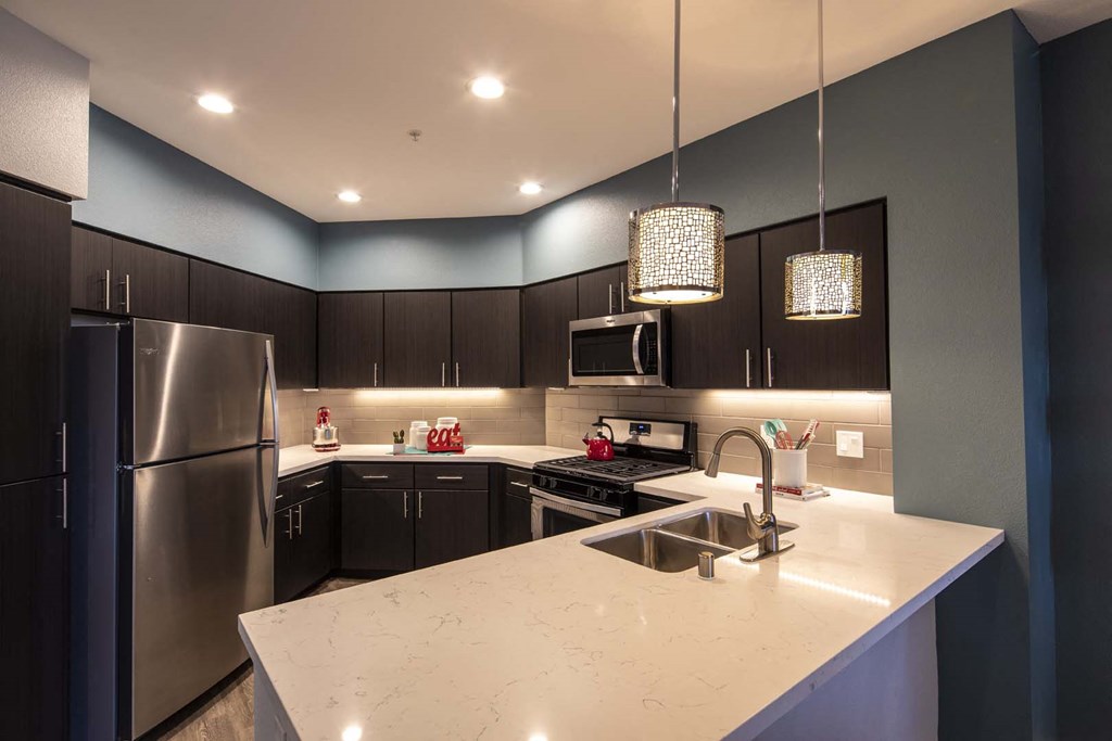 a kitchen with a large island and stainless steel appliances