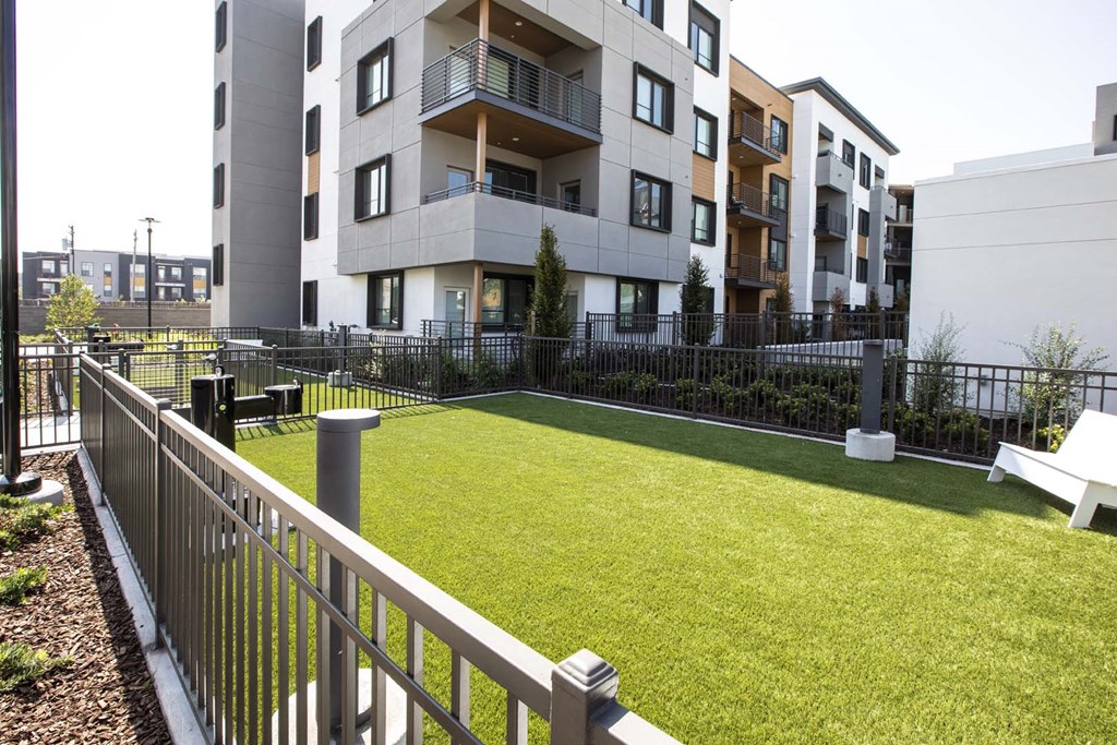 picture of an apartment complex with a grassy area and a fence