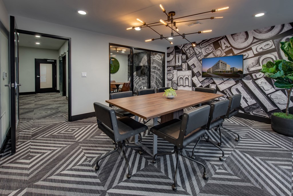 a meeting room with a large table and chairs and a mural on the wall