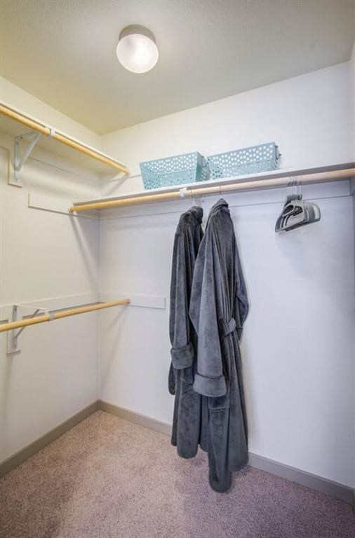 a walk in closet with a coat hanging on the wall