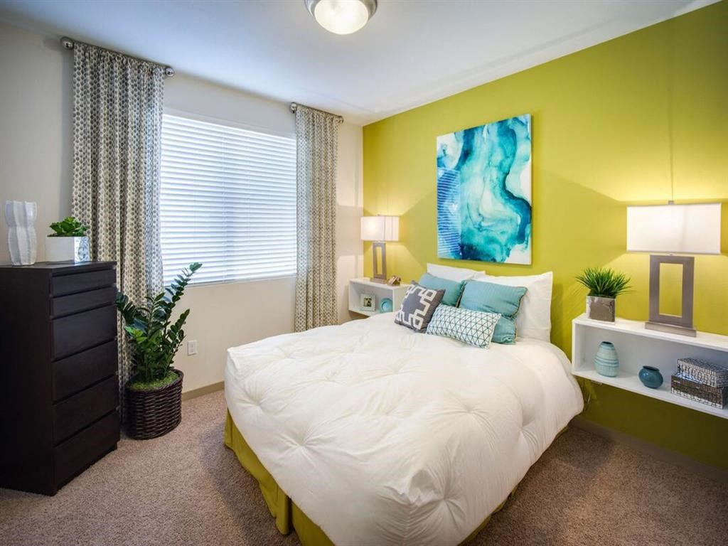 a bedroom with a large bed in front of a green wall