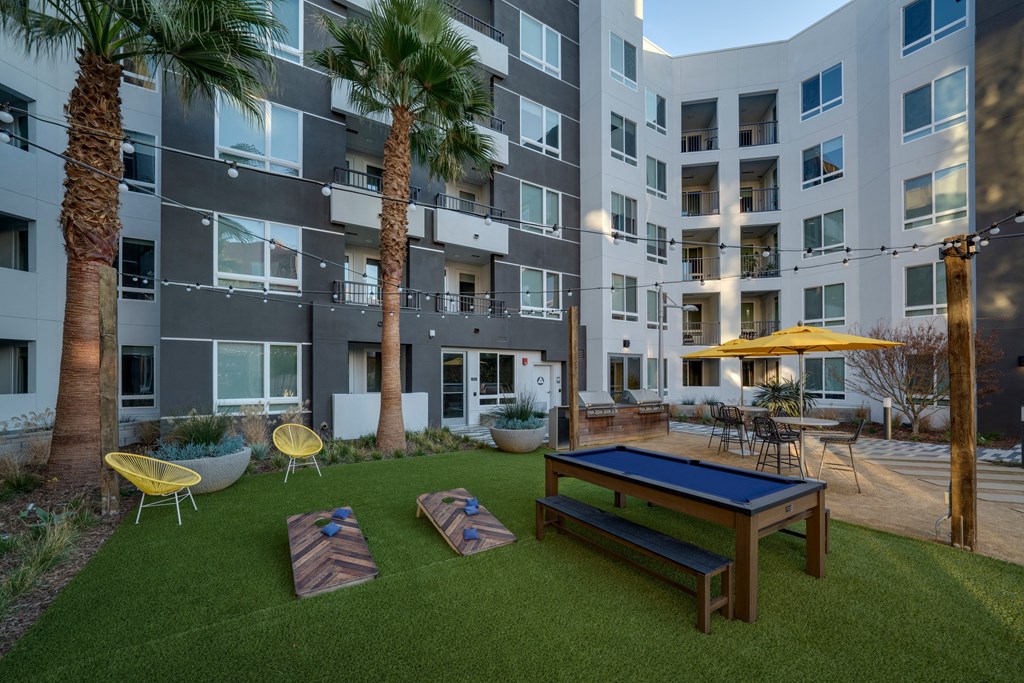 outdoor lounge with cornhole and pool table lounge seating