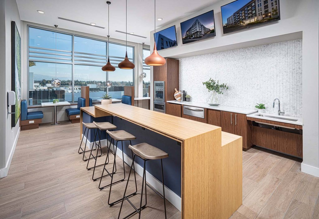 a kitchen with a long island and stools in front of a window