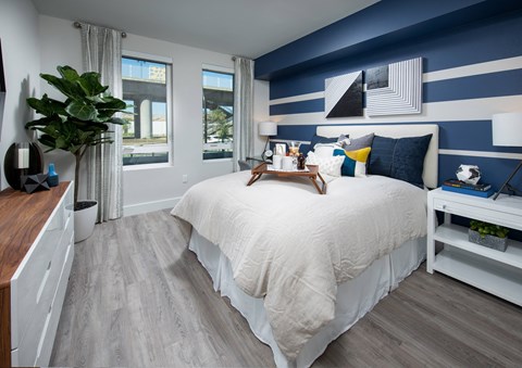a bedroom with a large bed with white and blue bedding and a blue and white striped