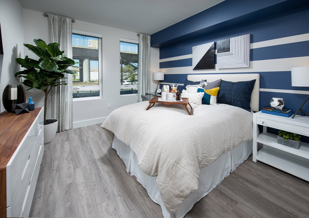 a bedroom with a large bed with white and blue bedding and a blue and white striped