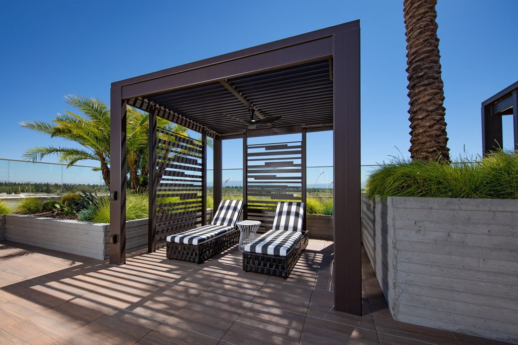 a covered patio with lounge chairs and a pergola