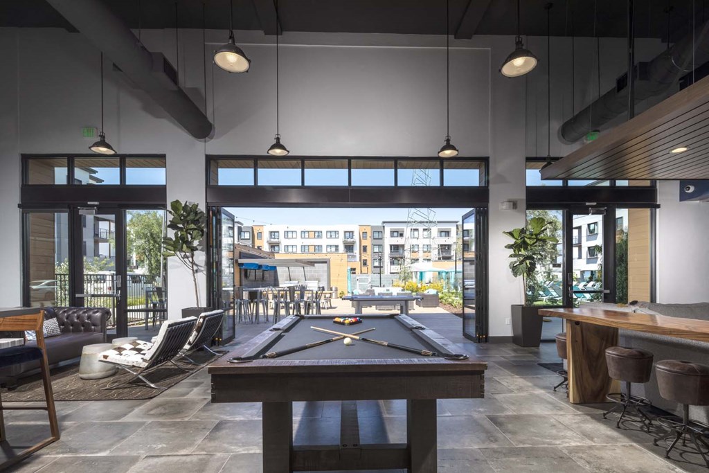 a pool table sits in the middle of a room with a bar